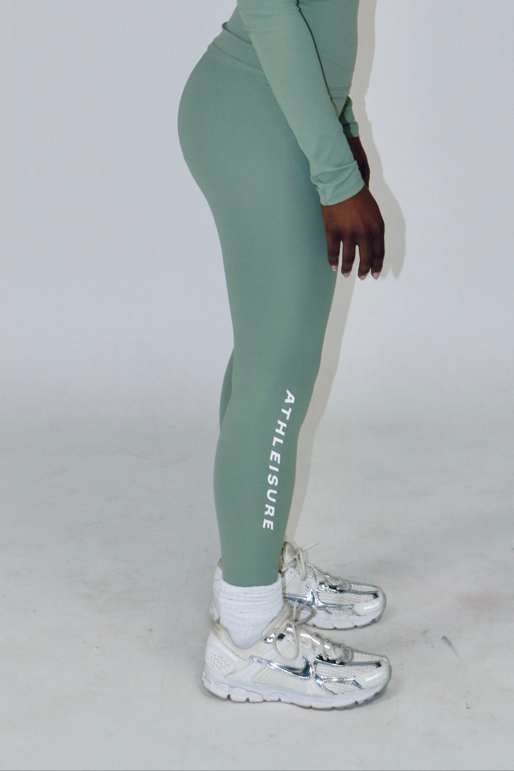 Person wearing a green outfit with 'Athle' branding on a white background