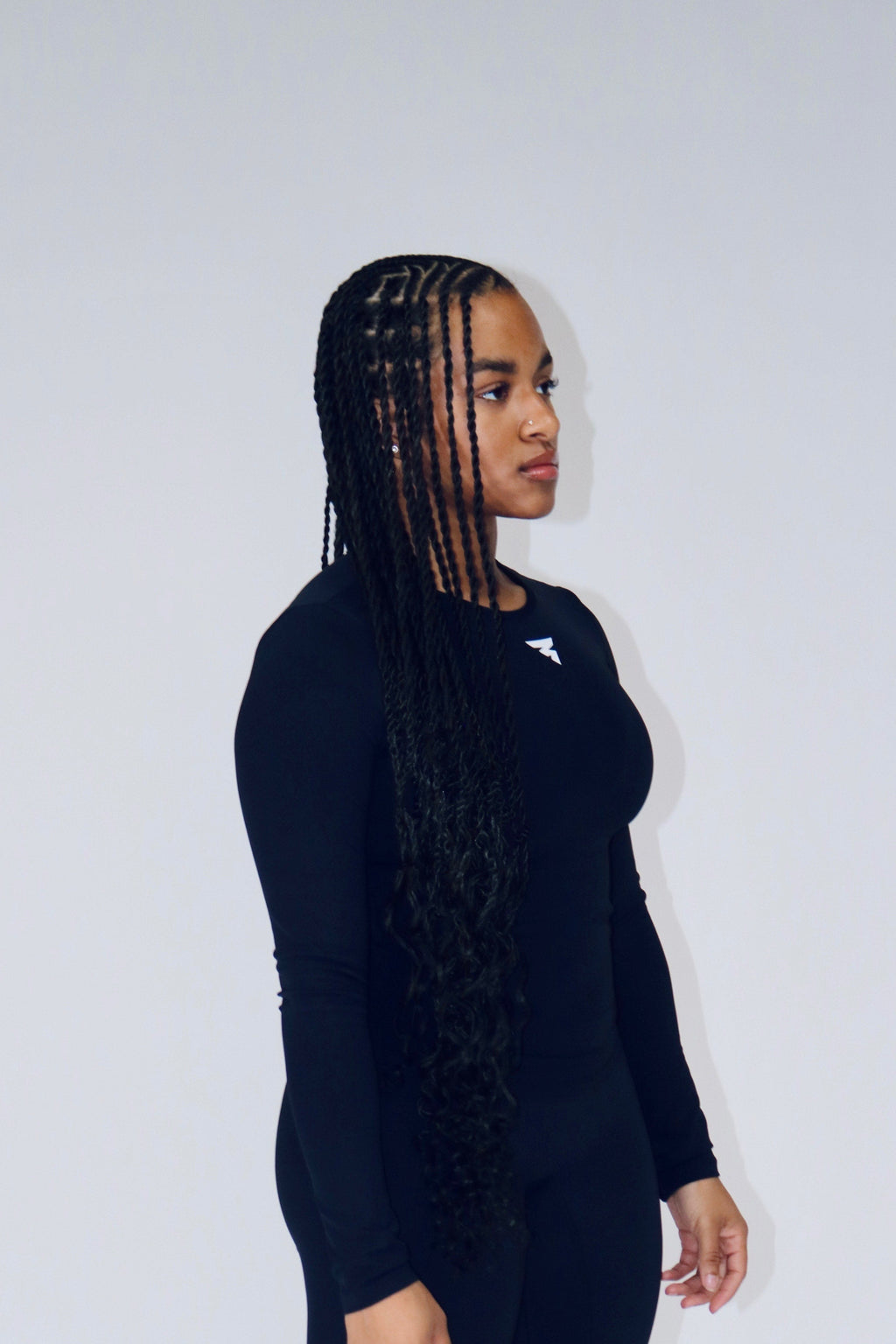 Person wearing a black outfit with white text on a white background